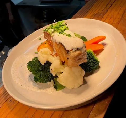 Salmon served with vegetables and a creamy sauce